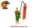 Le mandarin en costume vert a la bannière du jardin japonais miniature vintage